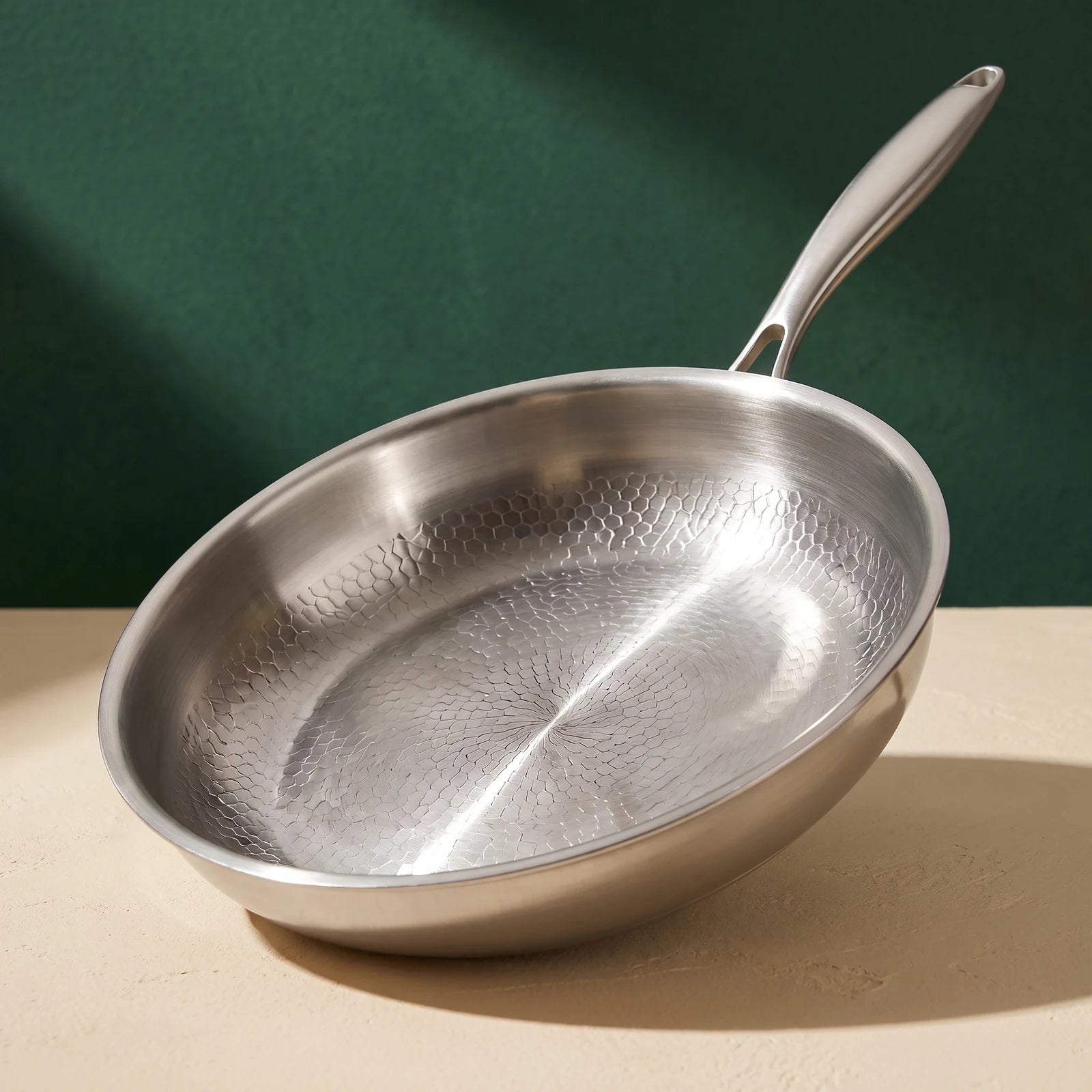 Titan Titanium Pan on a green and cream background